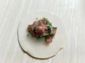 取一张饺子皮，放入适合的馅料。(饺子皮我是超市买的，如果自己和面，擀饺子皮也可以呦～)