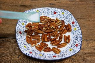 碧根果撒上一点点盐粉，均匀摊开；