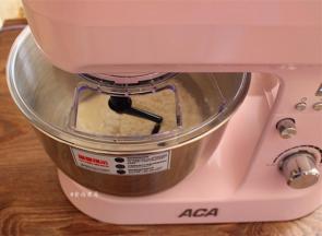 将不锈钢桶装于主机上，向下压不锈钢桶并扣好，接通电源，以一档的速度揉面20分钟，接着处理馅料