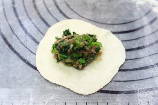 取一个剂子擀薄，放入馅料