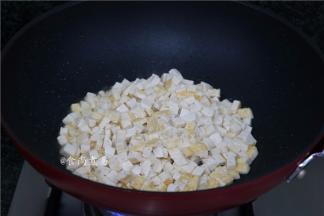 烧热锅，倒入橄榄油，将豆腐粒煸至焦黄色