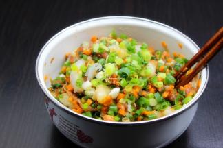 猪肉洗净剁碎，胡萝卜洗净剁碎，加入虾肉、香葱、油、盐、生抽、料酒、生姜、生粉等拌均腌制，可以放入冰箱，这样汁就多；