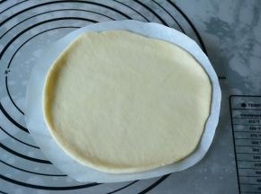 取一个面团压扁擀成一张大圆面皮。