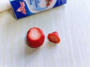 草莓洗干净后捞出淋干水份，将顶部的三分之一切下来。如图