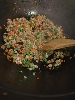 倒入适量油下锅先将肉炒熟，接着放入藕丁、胡萝卜丁、香菇丁、豌豆