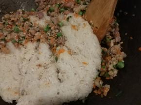 食材炒熟后放入事先蒸熟的糯米饭煸炒