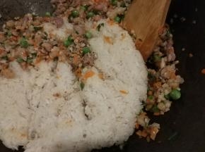 食材炒熟后放入事先蒸熟的糯米饭煸炒