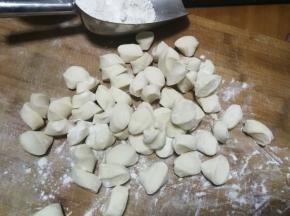 松弛后，将面团戳成长条，切成小剂子，撒少许干粉在案板上防粘