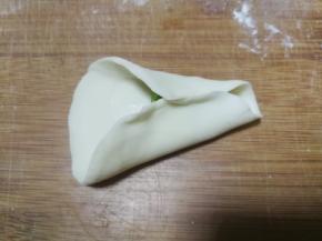 放了馅料的半边面片对边捏紧作为金鱼肚子部分，注意留出前段不要捏