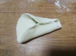 放了馅料的半边面片对边捏紧作为金鱼肚子部分，注意留出前段不要捏