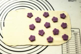 四份面团分别擀成厚片。在其中一片白色面片上放紫色花朵，一片紫色面片上放白色花朵。
这个是白底紫花。