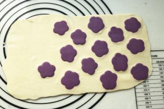 用擀面杖擀一下，使花朵充分黏合在面片上。擀的时候用力要均匀，不要把花朵擀变形了。