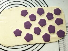 用擀面杖擀一下，使花朵充分黏合在面片上。擀的时候用力要均匀，不要把花朵擀变形了。