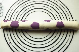 花朵朝下，上面摞上一片和花朵同色的面片，卷起来。