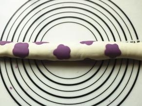 花朵朝下，上面摞上一片和花朵同色的面片，卷起来。