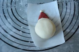 10.再取一小白色面团搓圆作为圣诞帽顶部装饰。将做好的圣诞帽紧贴着做好的雪人。