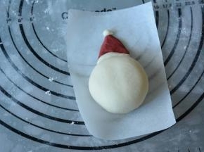 10.再取一小白色面团搓圆作为圣诞帽顶部装饰。将做好的圣诞帽紧贴着做好的雪人。