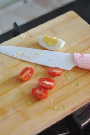 圣女果对半切开，鸡蛋也切成瓣状。