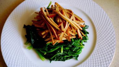 菠菜焯烫约30秒，捞出沥干水分，码放在盘子底部，再码放鸡蛋干条。