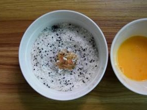 取肉末做成小丸子，先沾一层鸡蛋液，再放面包糠里滚一圈