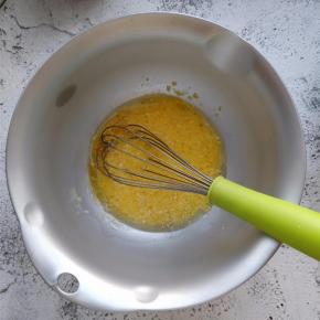 在蛋黄盆中，加入植物油和牛奶，用手动打蛋器朝一个方向搅动。