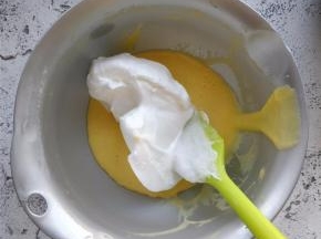 将三分之一的打发蛋白，加入到蛋黄糊中。