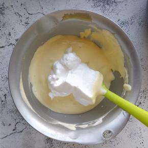 用刮刀从底部翻拌均匀，再加入三分之一的打发蛋白。