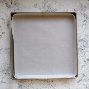 将金盘中铺上配套的油纸或不粘油布，边角整理好。