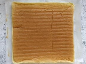 晾凉后将蛋糕体翻面，放在油纸上，入烤箱时的正面朝上。