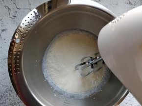 将冷藏后的淡奶油倒入打蛋盆中，加入糖粉后用电动打蛋器中低速打发。