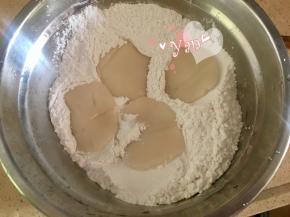 把煮熟的糯米小饼放入剩余的糯米粉中。