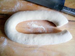 然后往开抻，用手向拔河一样捏着往开拉，用刀在一端切开