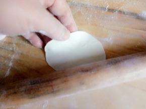 用擀面杖顺着四周擀开，擀成中间厚四周薄的面皮