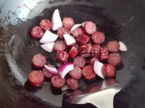 炒锅里放适量的油，放入洋葱炒出香味，放入腊肠煸炒至出油