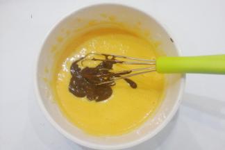 接着再把融好的可可粉加入蛋黄糊中继续搅拌均匀备用；