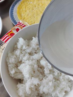 刚做好的米饭盛入大碗里，倒入适量的寿司醋搅匀，尽快让米饭散热；我用现成的寿司醋，但感觉口味不合适，又添加了少许的糖、盐调理一下；寿司醋的用量要根据自己的口味调整；