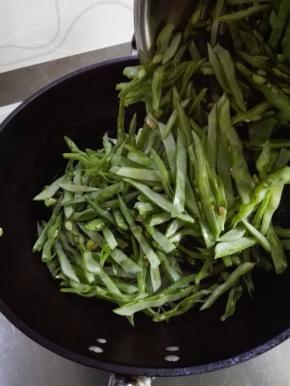 炒至洋葱丝变半透明时，放入扁豆丝翻炒