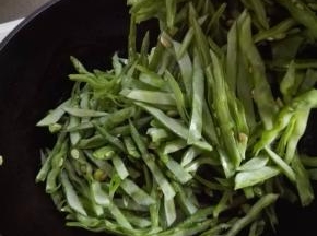 炒至洋葱丝变半透明时，放入扁豆丝翻炒