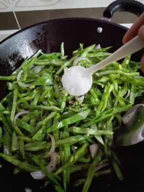 炒至扁豆稍微变色时，放入一小勺糖炒匀