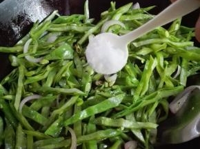 炒至扁豆稍微变色时，放入一小勺糖炒匀