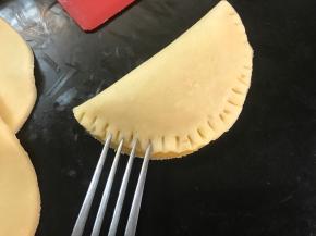 然后对折起来，捏紧后用叉子在边缘压出花纹。