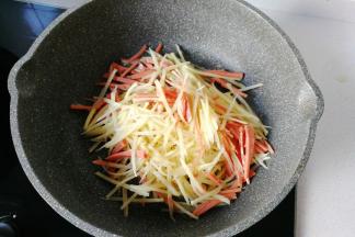 不粘锅中入少许油，放入火腿土豆丝先翻炒一下；