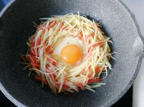 中间打入一颗鸡蛋，小火慢煎；