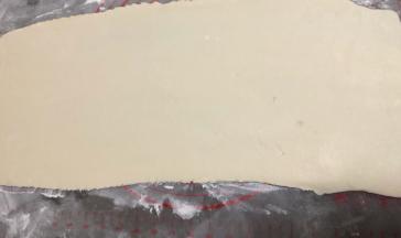 桌上撒些干粉，一分为二擀开，后檊的面团先用保鲜膜盖好，防止吹干