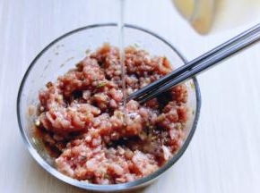 肉糜器具中加入鸡蛋。切碎的葱姜蒜末。料酒。生抽，盐，胡椒粉，食用油搅拌均匀。