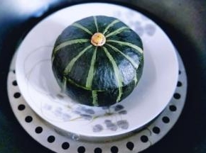 切下来的盖子盖上。放入深一点的盘子中，入锅隔水蒸25左右，要根据南瓜的大小来增减时间。