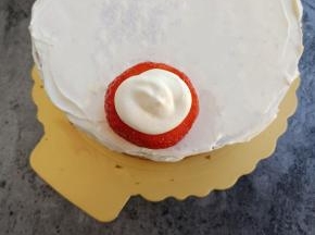 草莓底部放在蛋糕上，挤上一圈奶油