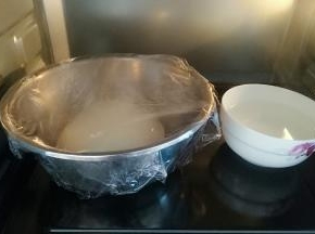 将面团整圆，盖上保鲜膜，放入烤箱发酵，放一碗热水，发酵至二倍大