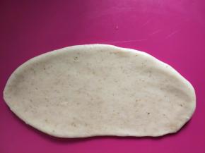 取一个面团擀开呈舌状。