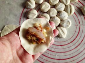 15.	取一个面盘，把馅放在中间，再放上一个虾仁，包好，